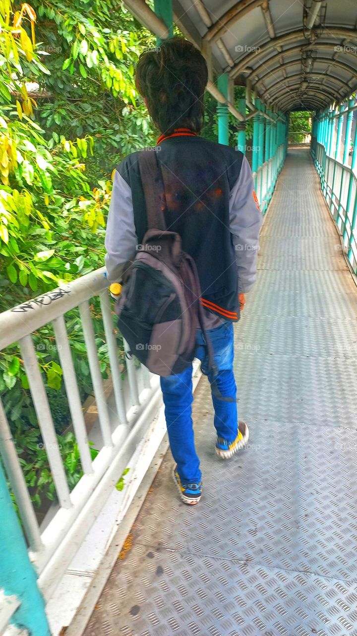 Portrait of a teenager walking on a highway bridge crossing