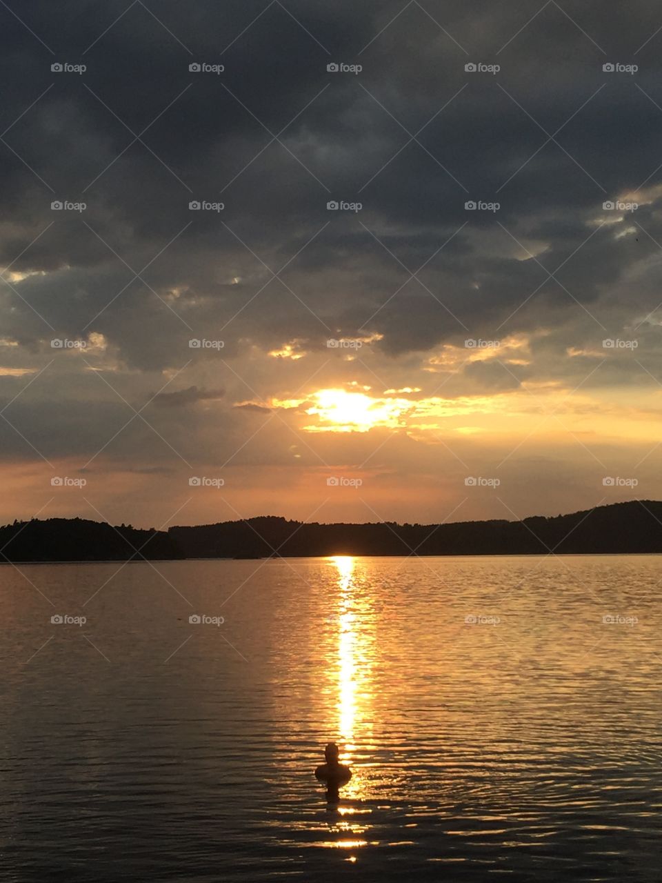 Man swimming during sunset