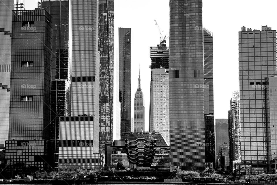 Midtown Manhattan seen from the Hudson River shows several skyscrapers and interesting structures including the Vessel and the Empire State Building