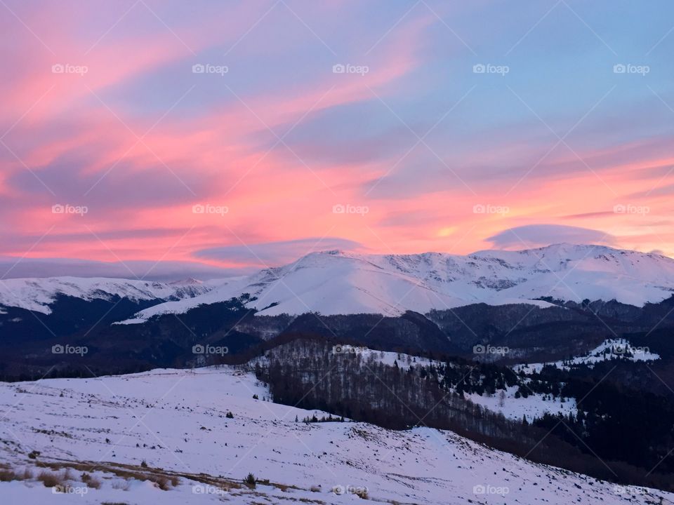 Sunset over the mountain range in winter