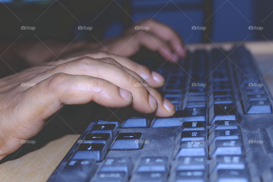 A professional person typing or using an office laptop keyboard. View of a online social media marketing executive network worker working on a desktop computer, business concept
