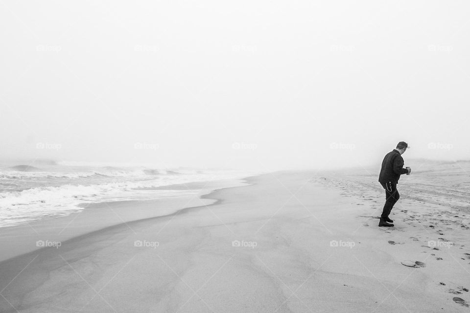 Man walks on the beach, man turns back on the ocean, walking in Long Island New York, walking on the beaches of East Hampton 