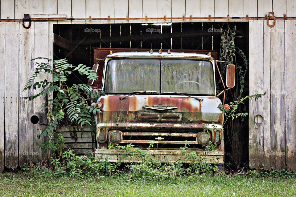 Old rusty truck parked in old Barn