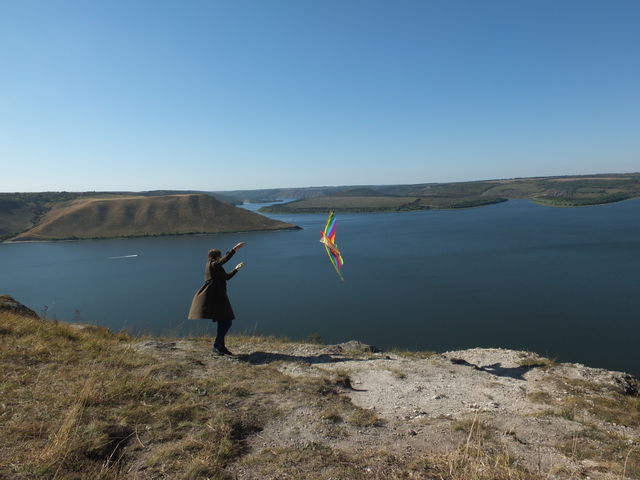 A woman flies a flying kite over a reservoir in Bakota.