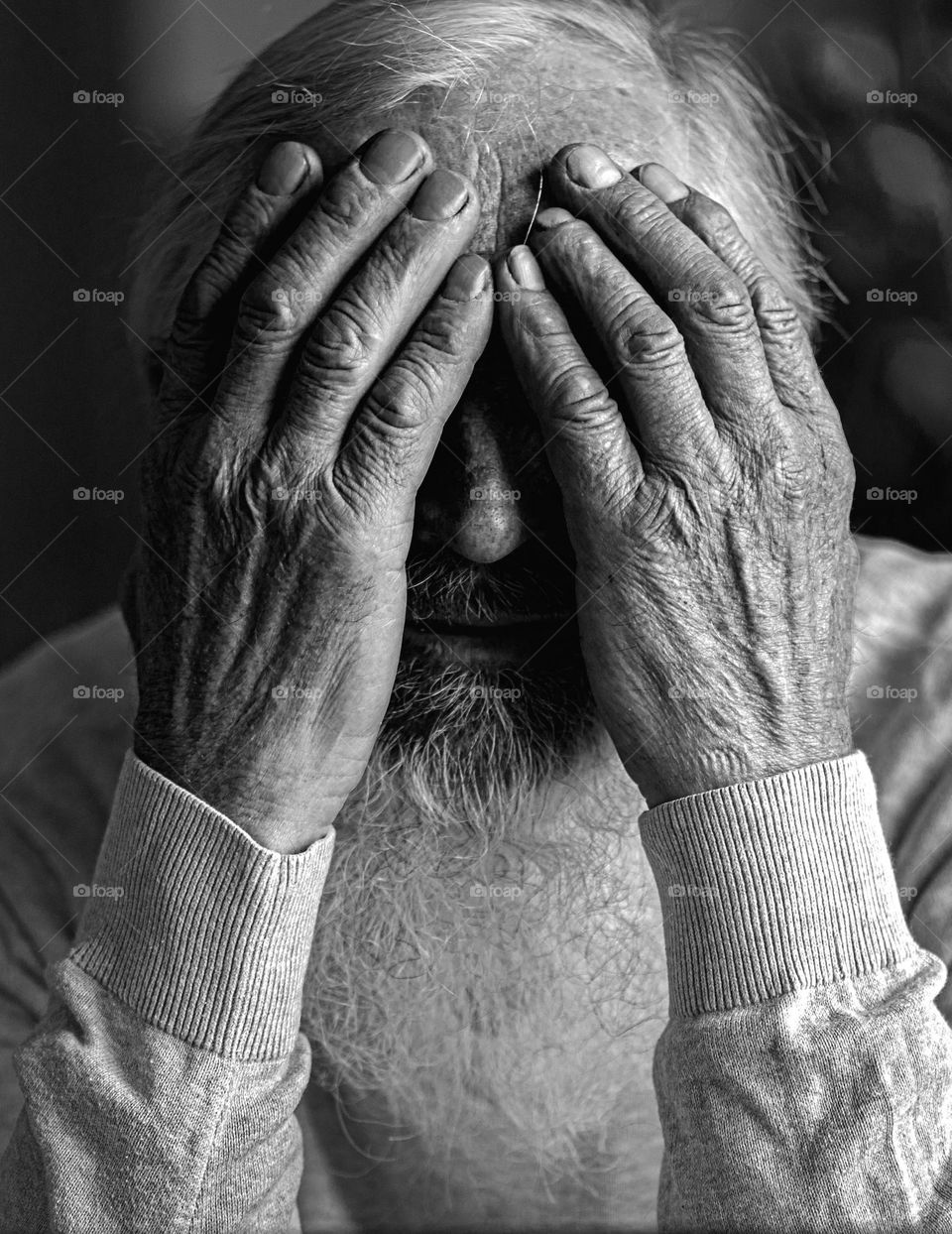 Old mam hides his face in his hands