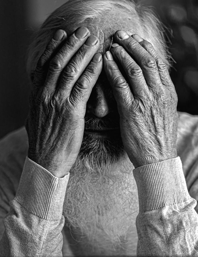 Old mam hides his face in his hands