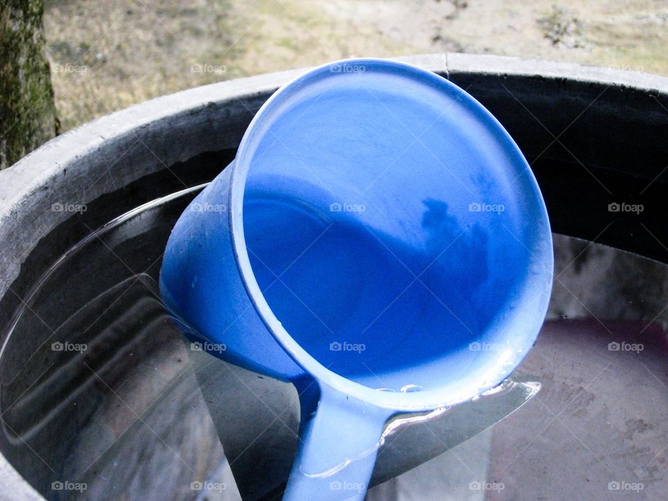 a blue dipper placed on top of a gray bucket