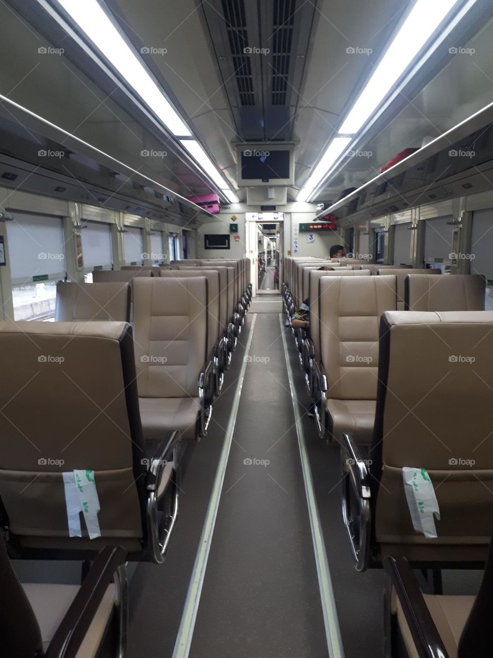 The design of the light brown colored train passenger seats on the train looks empty in the morning