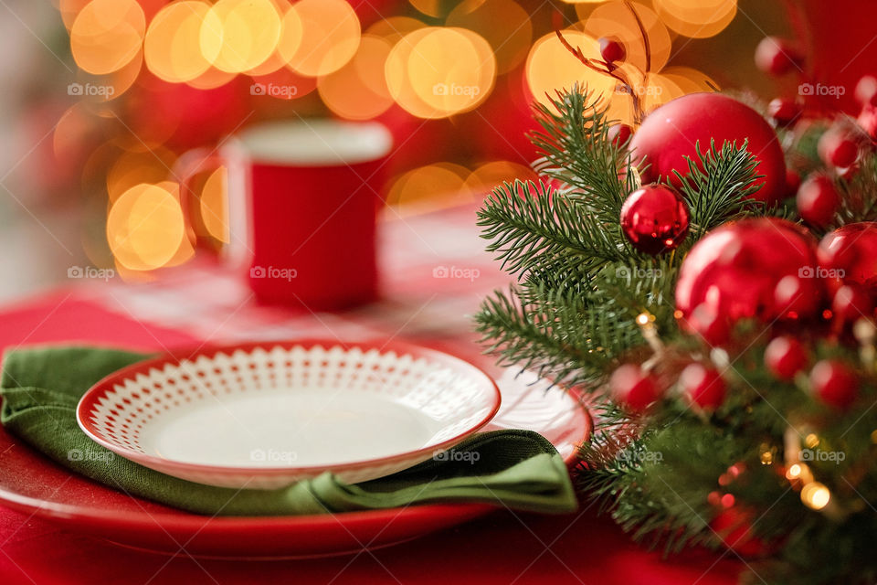 Festive winter cozy kitchen interior with garlands, decorations and gifts.  Christmas dinner at the decorated table.