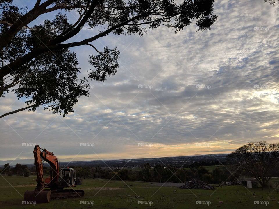 Digger resting in the paddock against a setting sunset