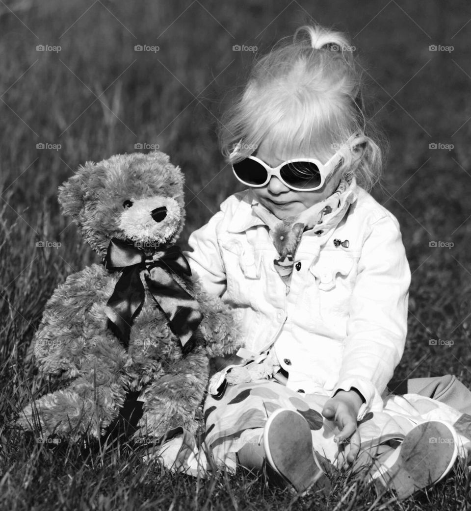 Little Girl with bear playing in the fields