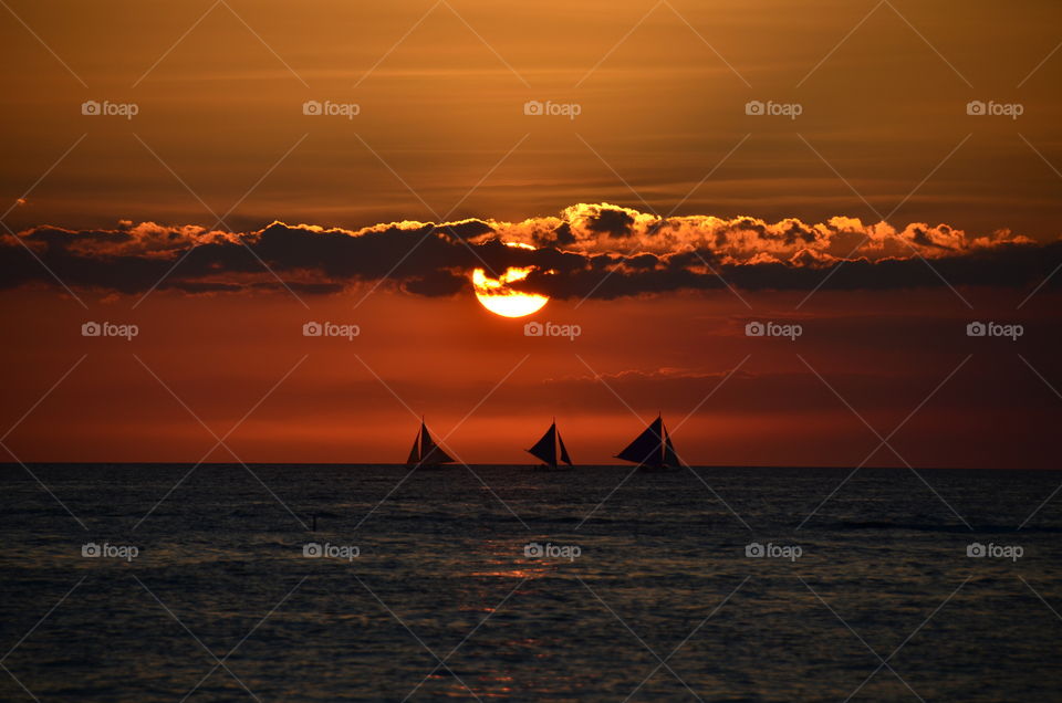 Sunset at sea and three boats