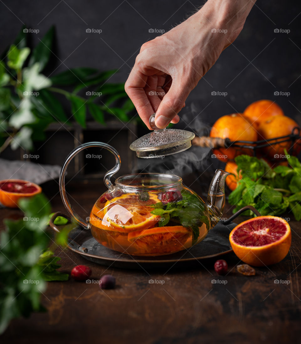 Orange and mint tea. Put 1 sliced orange, some cranberries, few mint leaves and sugar in a tea pot and add hot water.