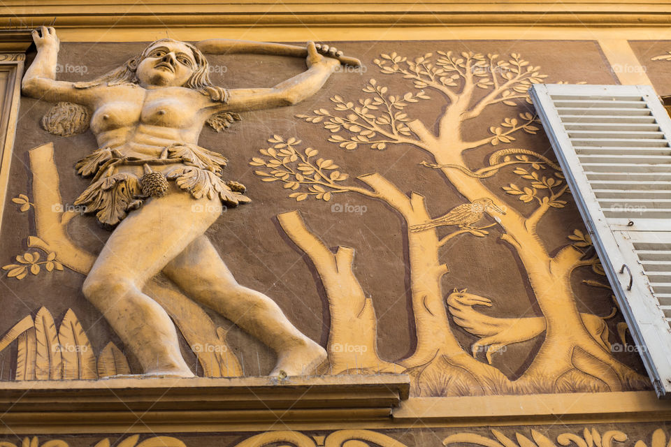 Looking Up at Bas Relief . Art on wall of French building 