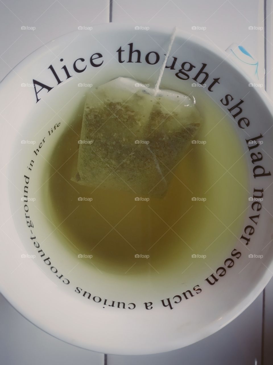 Green Tea Bag Steeping in an Alice in Wonderland Quote Tea Cup :)