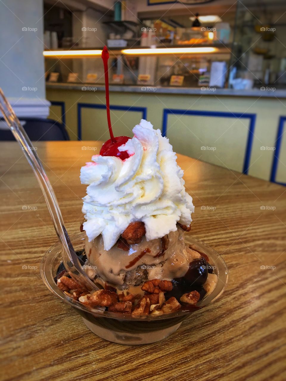 Ice Cream Sunday with Whipped Cream, a Cherry and Nuts on a Table 