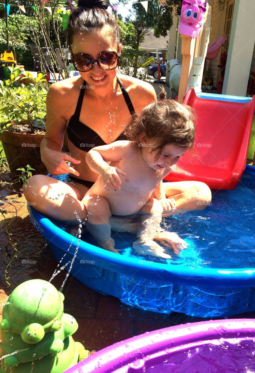 Mother and baby bathing in bath tub