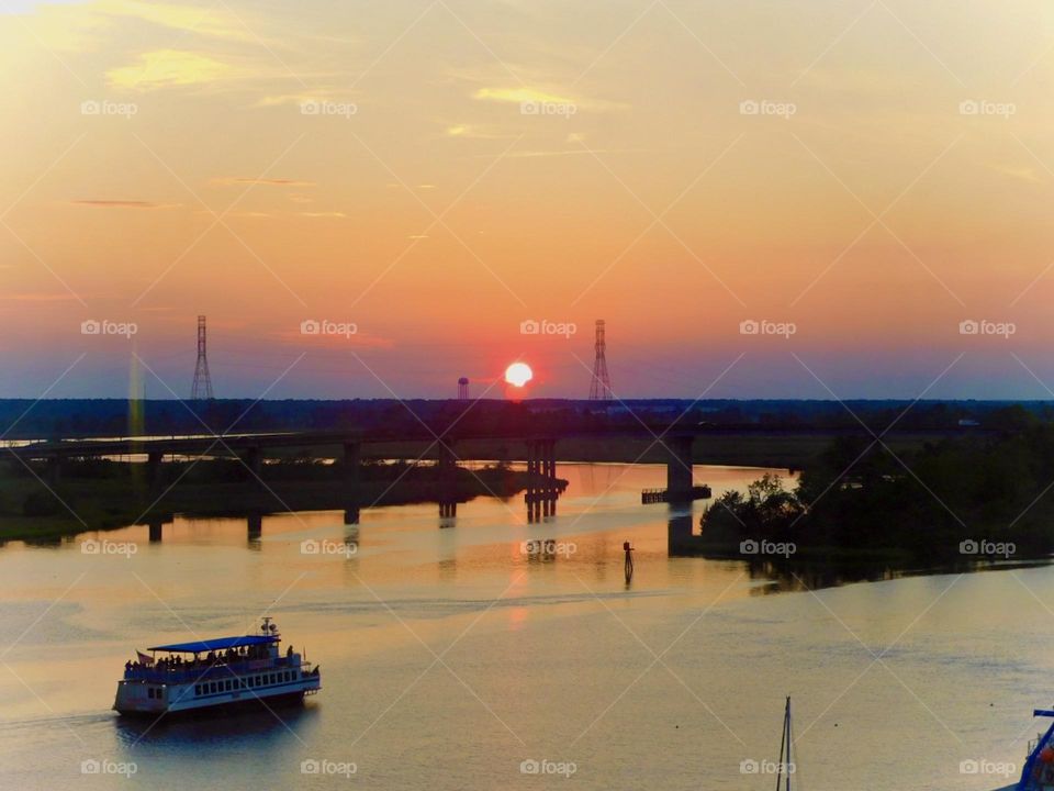 Blue and orange sunset over busy river 