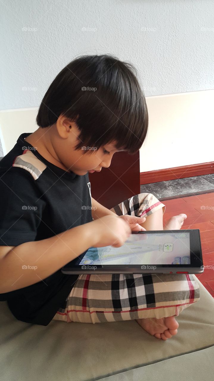 young boy playing tablet