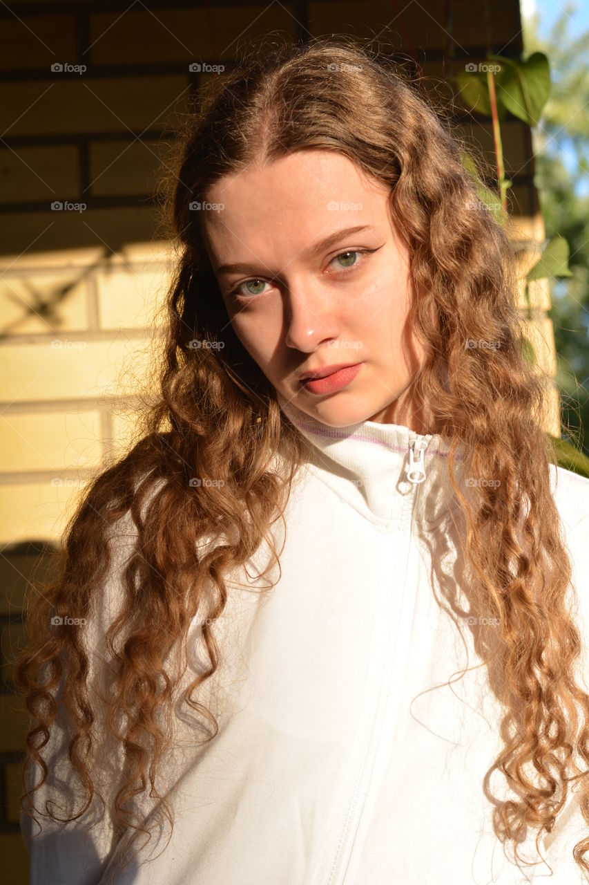 brunette girl beautiful portrait close up in sunlight brick wall background