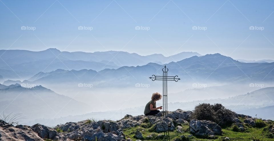 Girl looking at her cellular on top of the mountain 