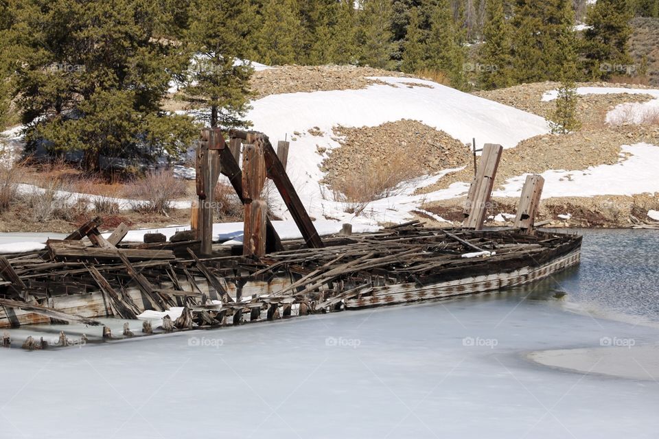 An abandoned gold mining dredge, frozen in a mountain lake in Colorado. 