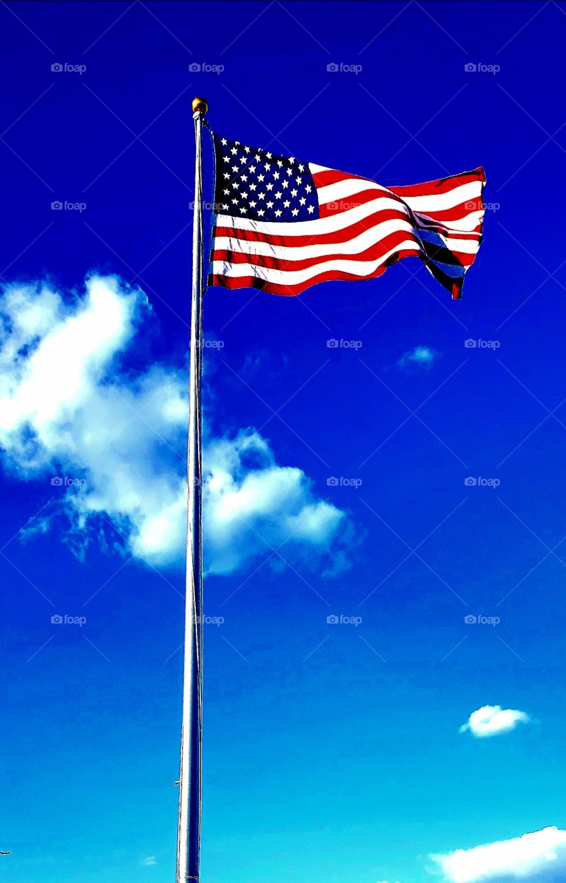 American flag waving in bright blue sky