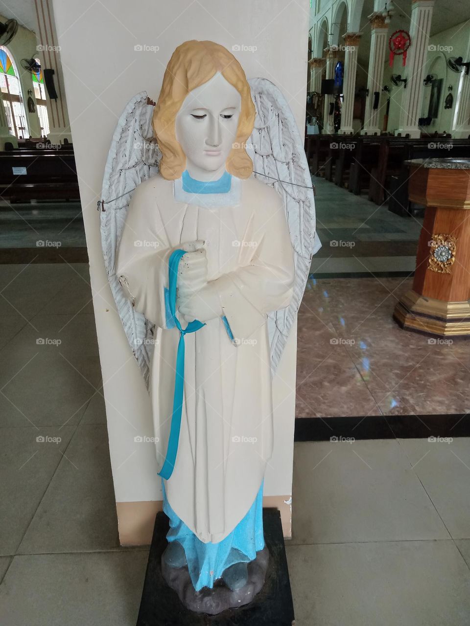#COLOR:WHITE, A SCULPTURE OF A GUARDIAN ANGEL AT THE ENTRANCE OF THE CHURCH