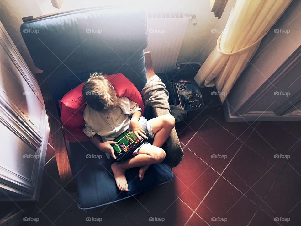 Boy playing on tablet at home