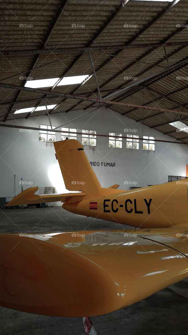 Avión amarillo estacionado en base militar