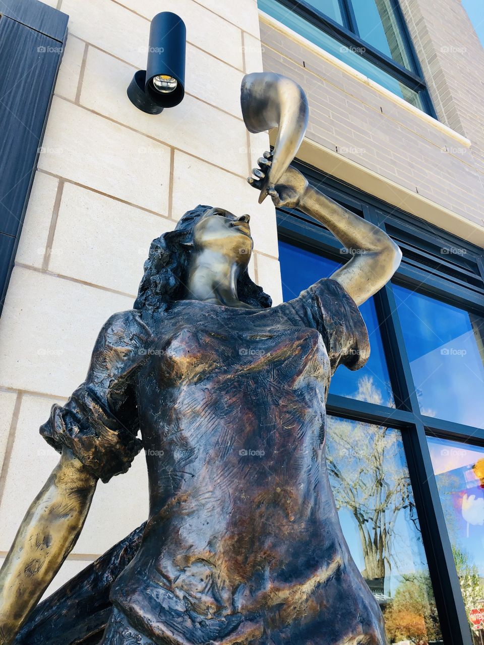 Bronze sculpture of a woman with a horn