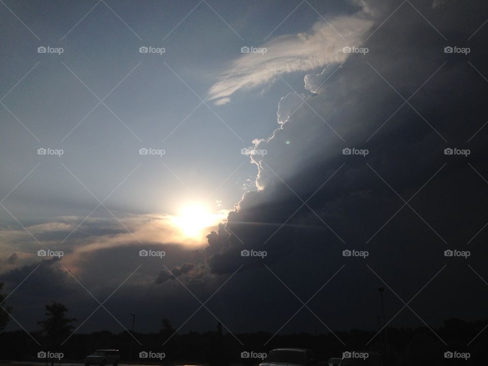 Sun meets storm. Sun rising next to storm clouds