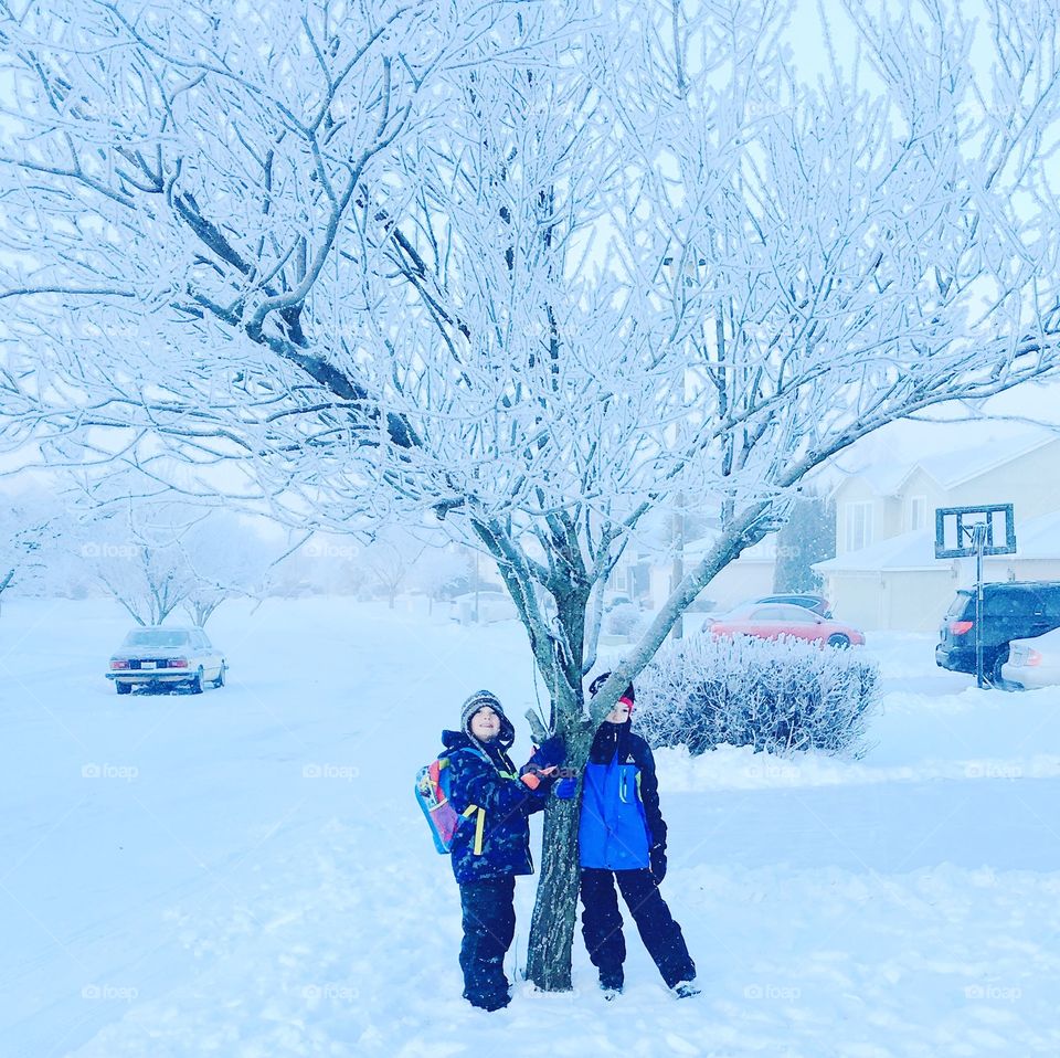 Two kids standing under tree