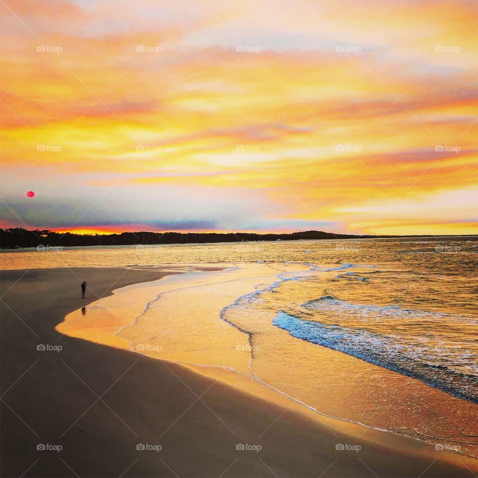 The golden sand and red sky at sunset 