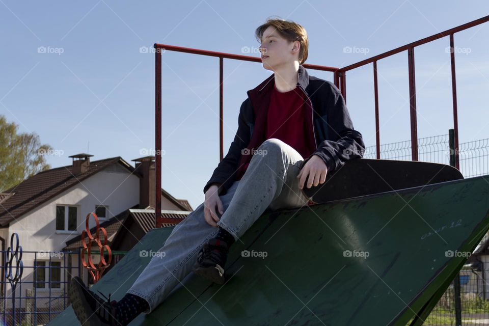 Hobbyist teenager goes in for sports, has fun and rides a skateboard in the park outdoors.