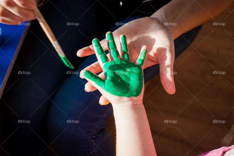 Green kid’s hand in creative process