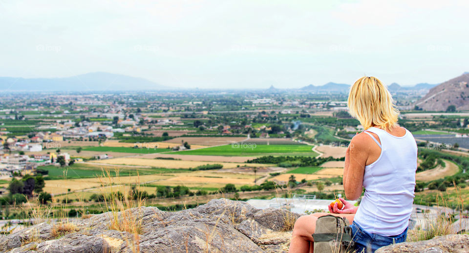 Hiker at the top of a mountain relaxing and eating an apple