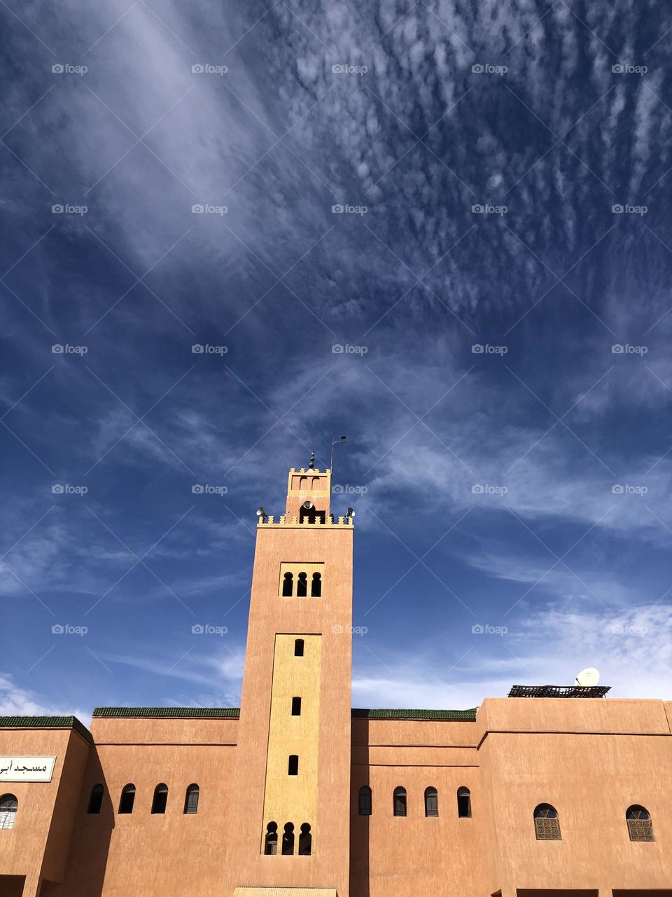 Beautiful minaret of a mosque embracing the sky .