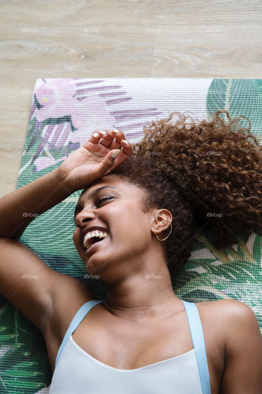 Woman laying down on yoga mat smiling