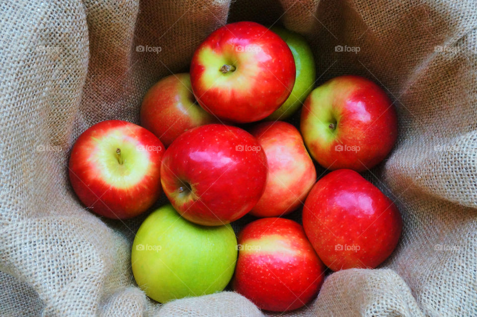 Green and red apples on fabric background 