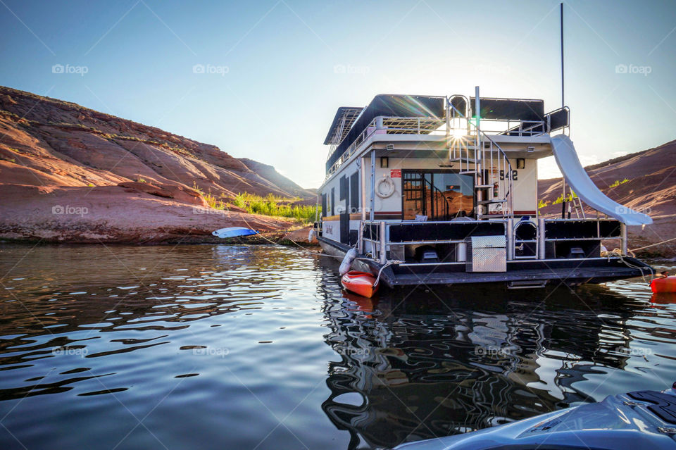 Evening light shines on a house boat beaches at Lake Powell in Utah. 