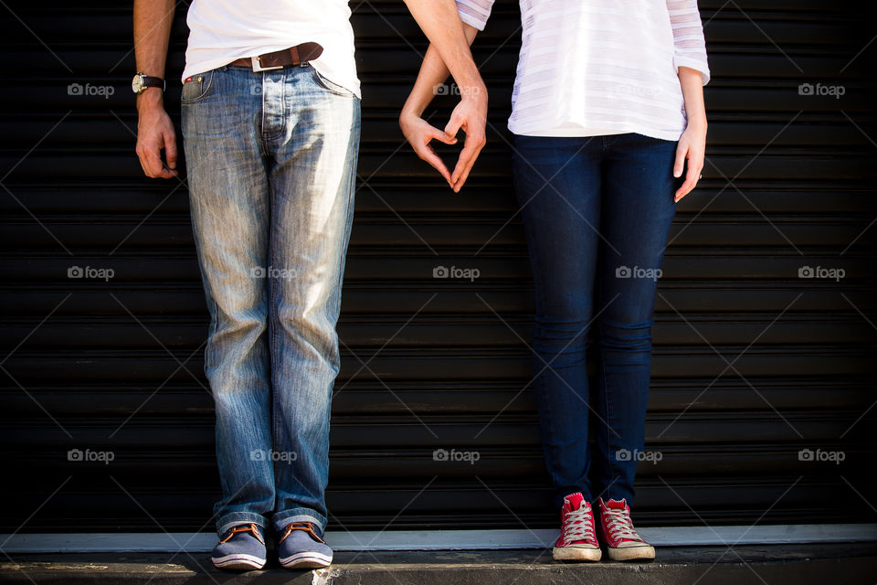 Summer memories of love and being together. Image of couple forming heart with their hands.