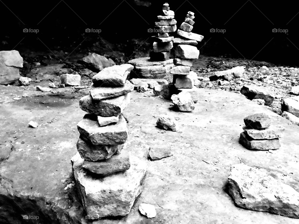 Black and white photo of stacks of rocks found underneath natural bridge in Missouri. 