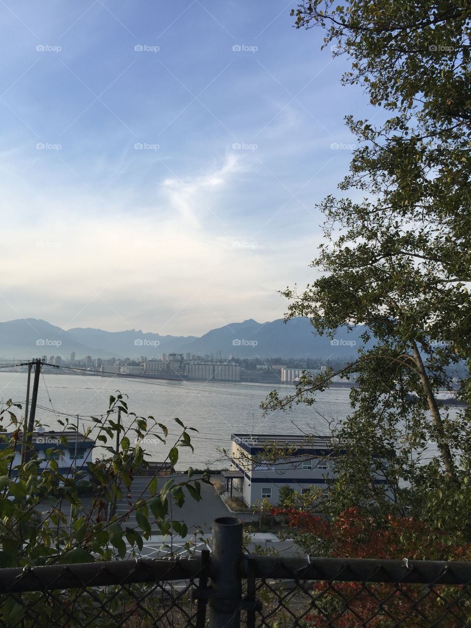A view of the industrious side of North Vancouver with the mountains towering behind and the ocean flowing in front in British Columbia.