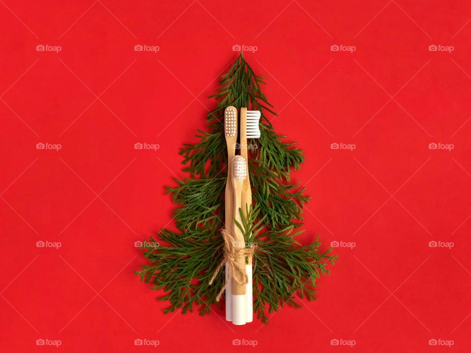 Bamboo toothbrushes and Christmas tree on red 