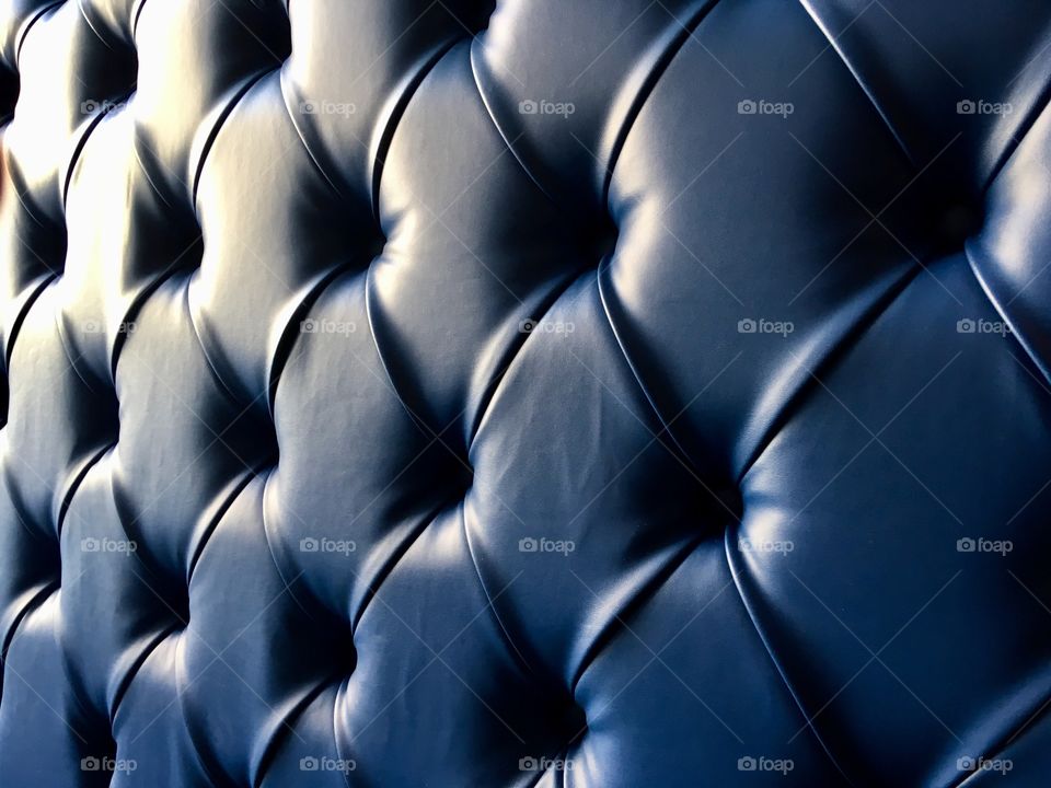 Interior upholstery showing light and shade on a blue leather sofa, situated in a 3 story hotel in Ilfracombe, North Devon