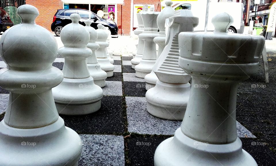 White chesspieces on a giant chessboard