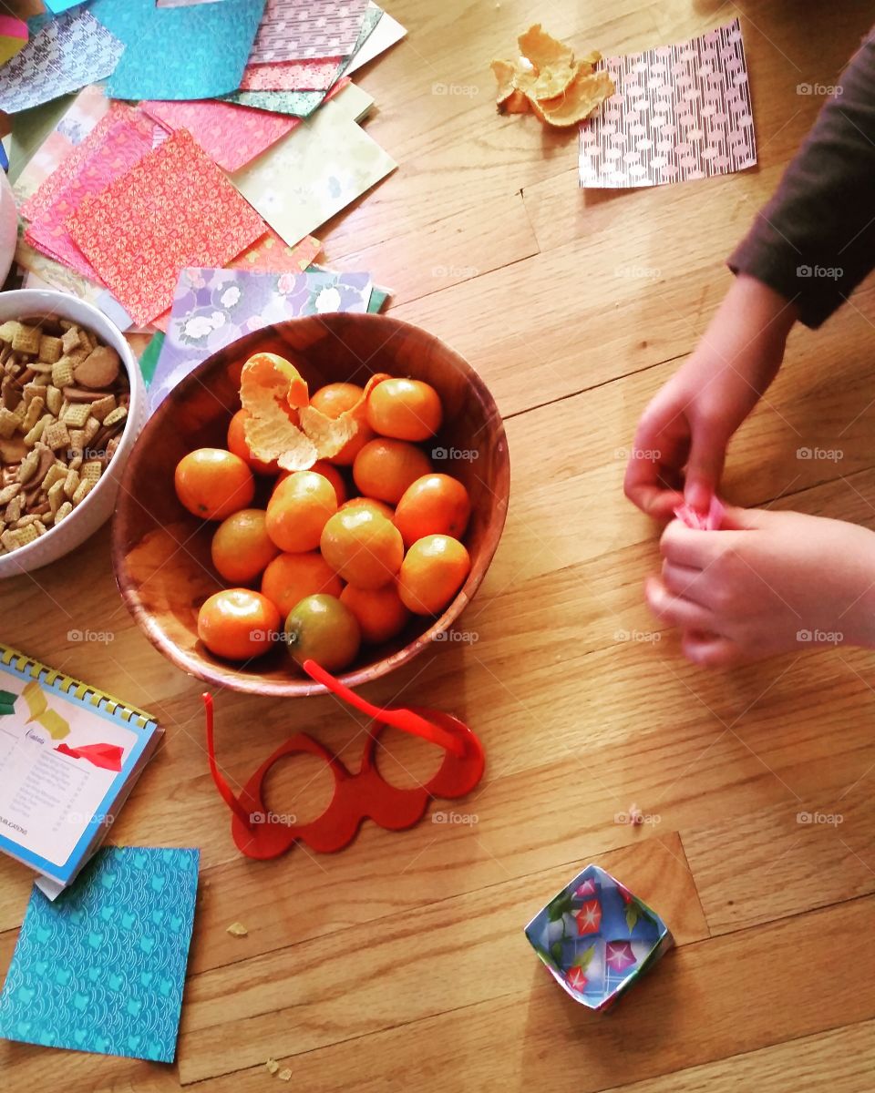 person completing craft project with bowls of snacks