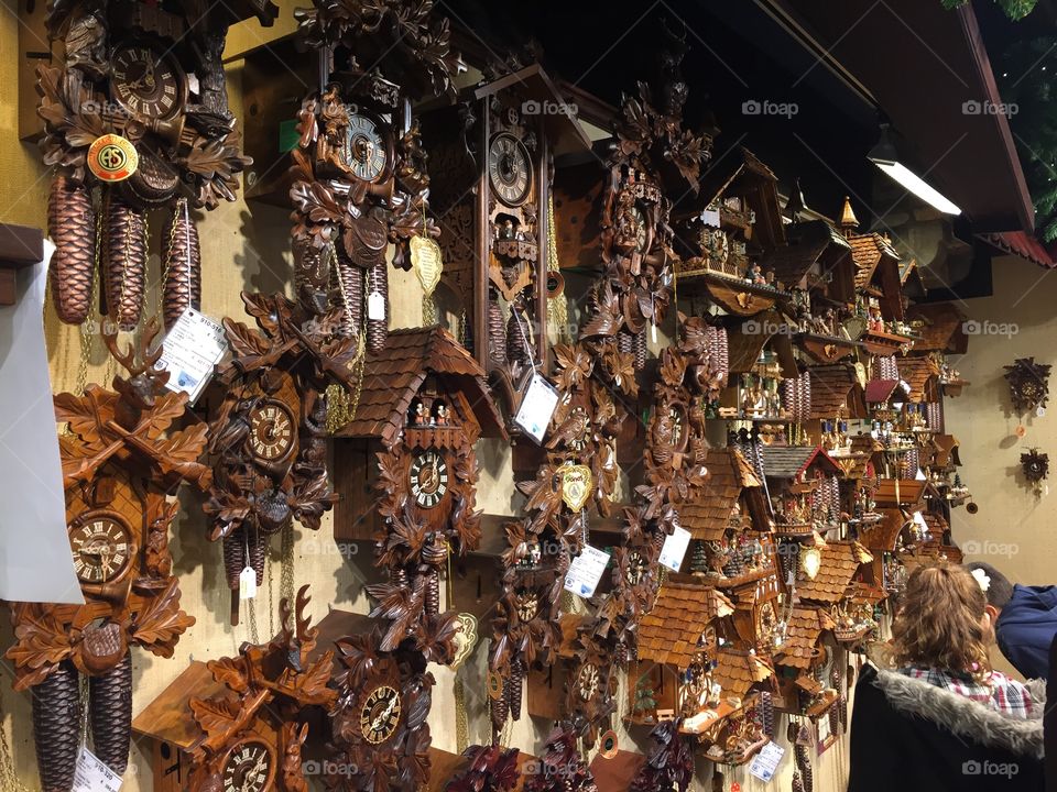 Cuckoo clocks . A wall of many different shapes and sizes of clocks 