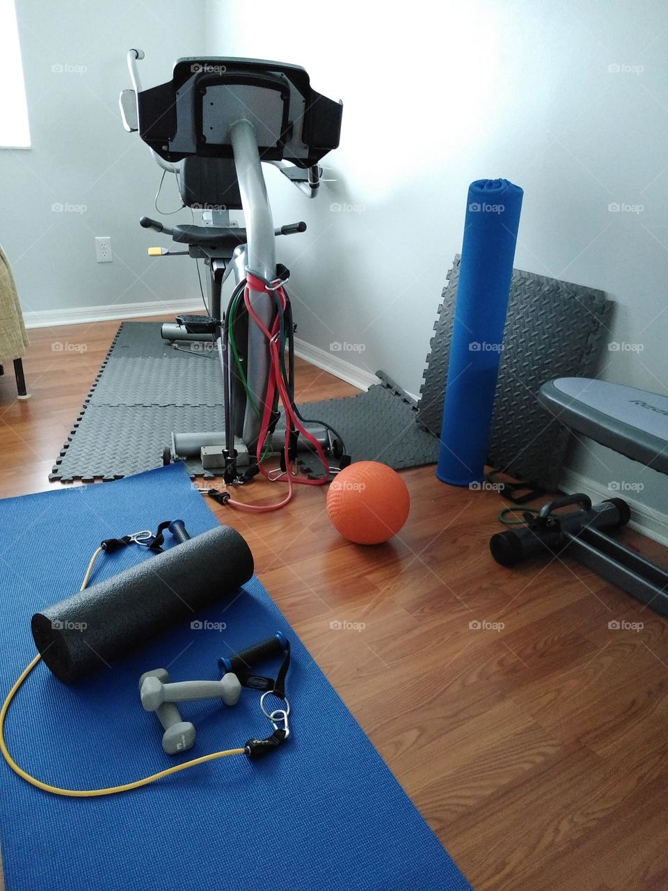 A treadmill, weights, a yoga mat, are some of the things in my friends exercise room.